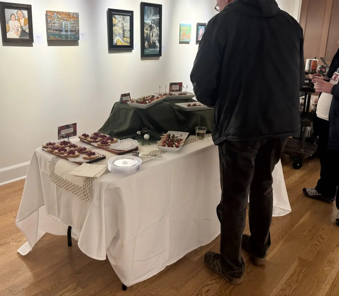 A guest browsing a canape table at a gallery reception