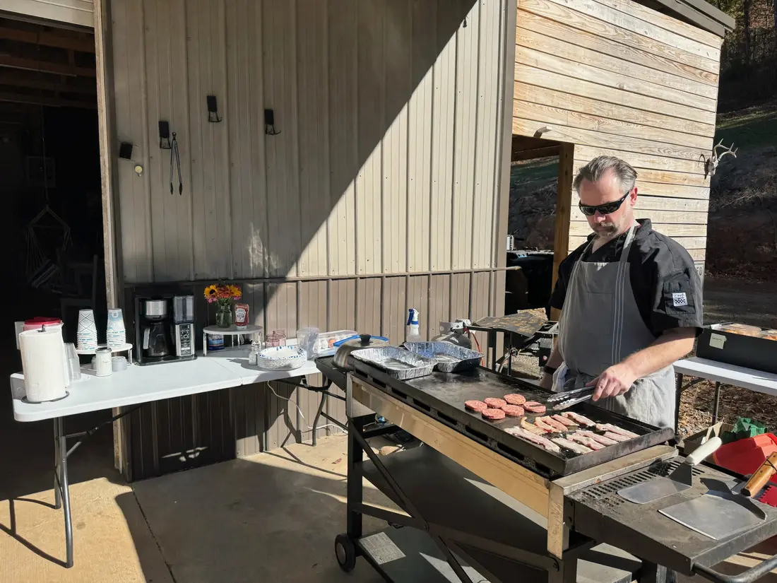 A chef working a flat-top griddle at an outdoor catering station